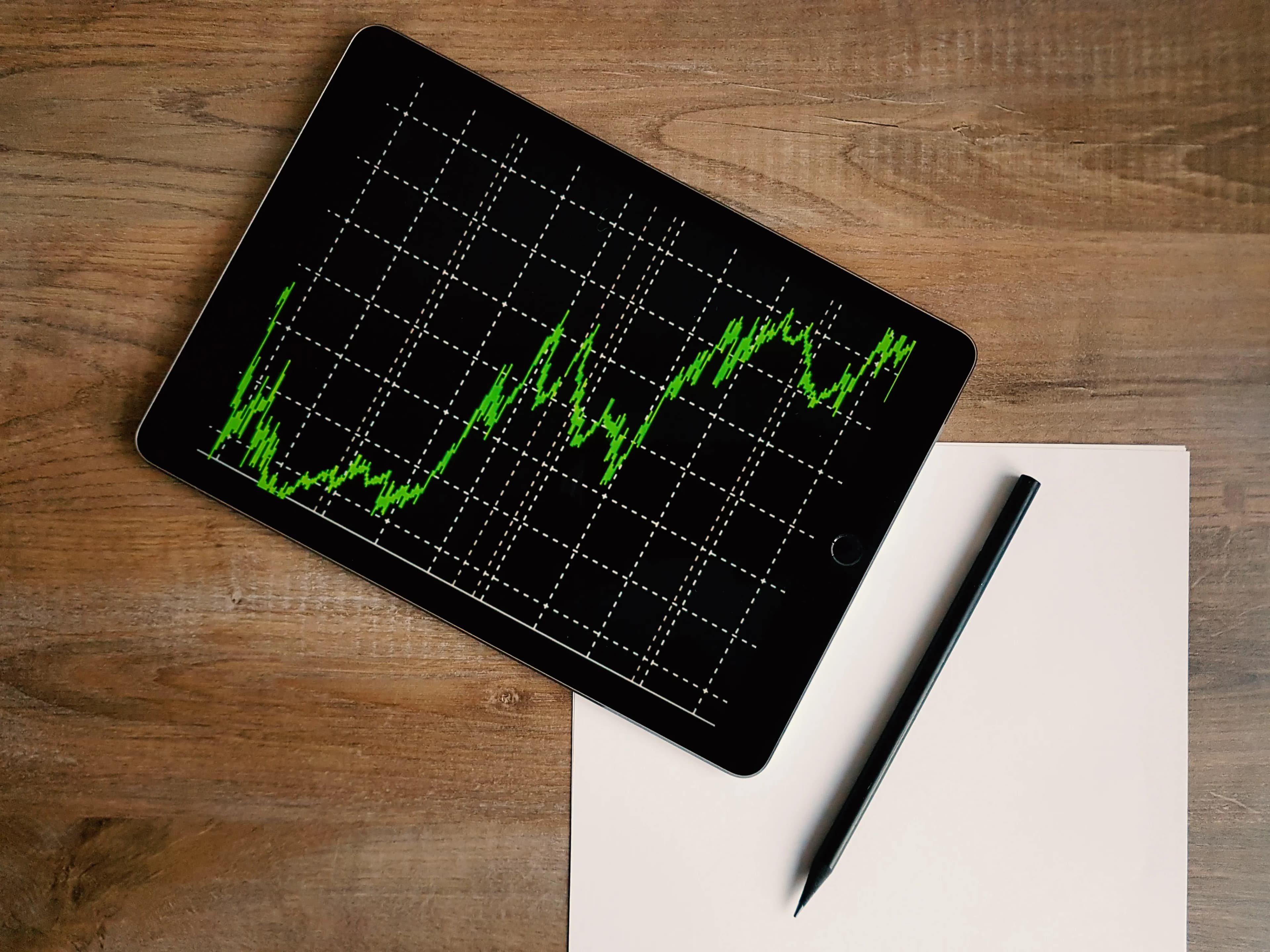 A green stock chart on a tablet, representing growth versus value investing strategies