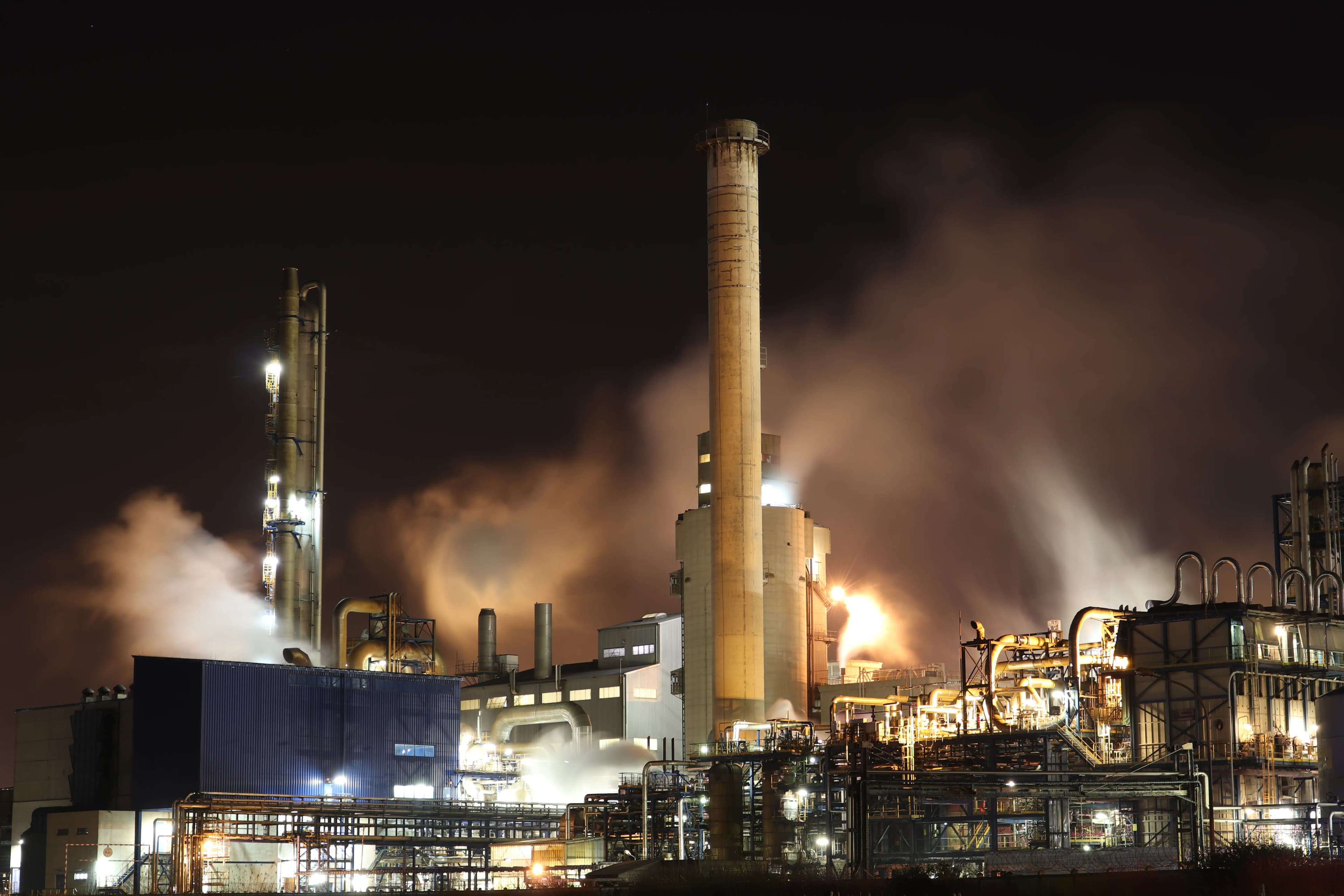An oil refinery lit up at night, representing the history of Petrobras and Brazils oil industry