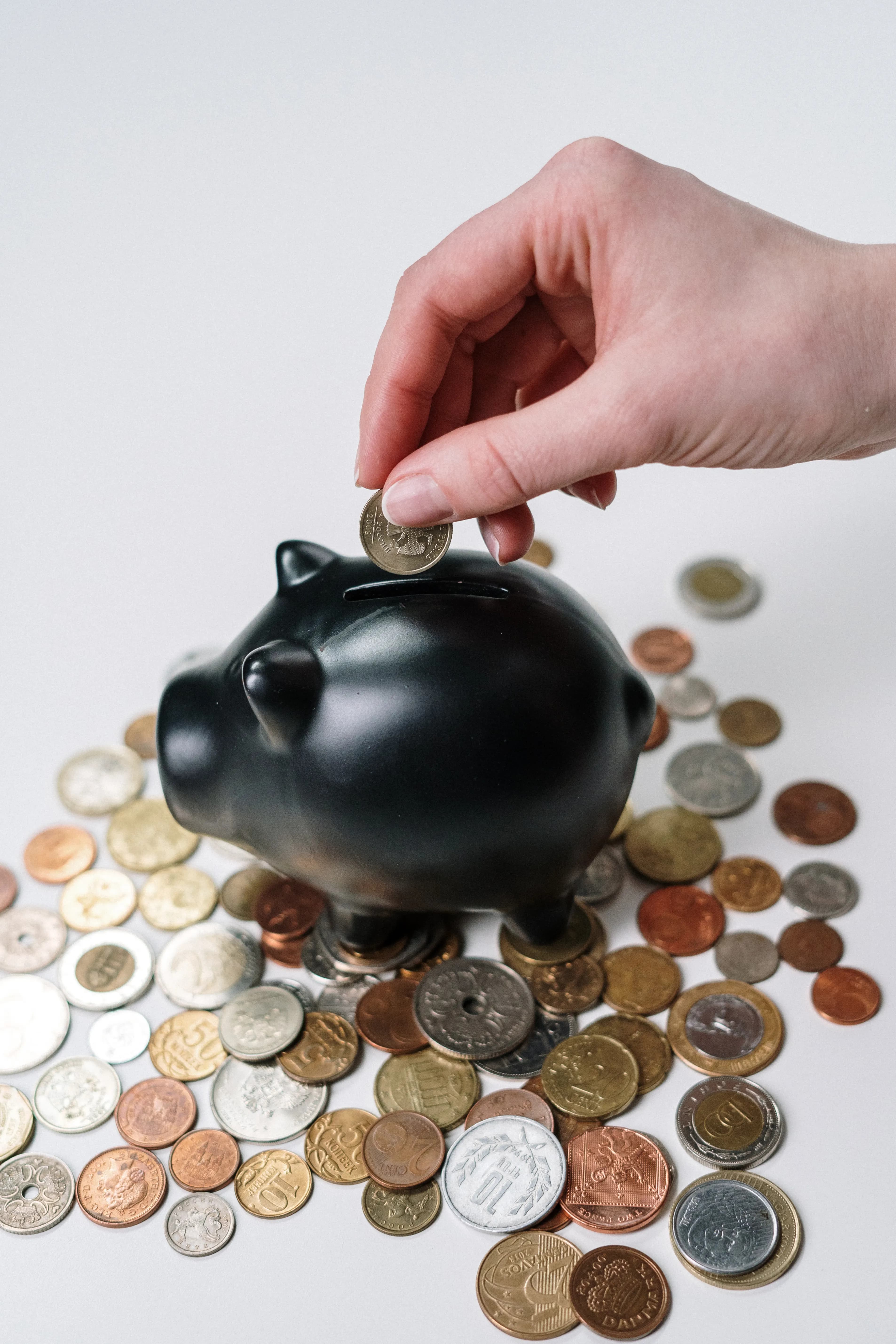 A black piggy bank surrounded by coins, representing dividend ETF income for 2026