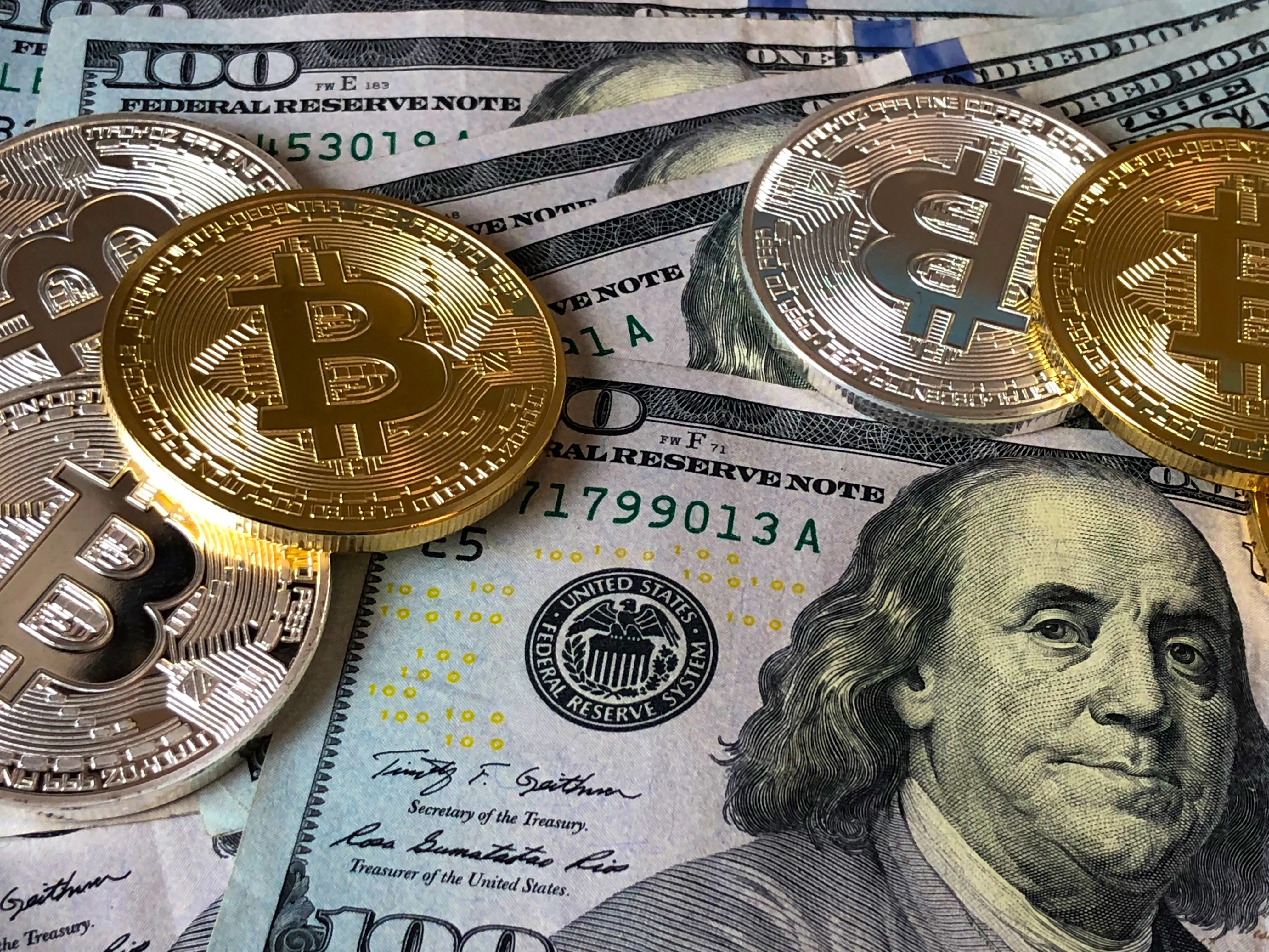 Bitcoin coins resting on US dollar bills, representing the latest cryptocurrency news