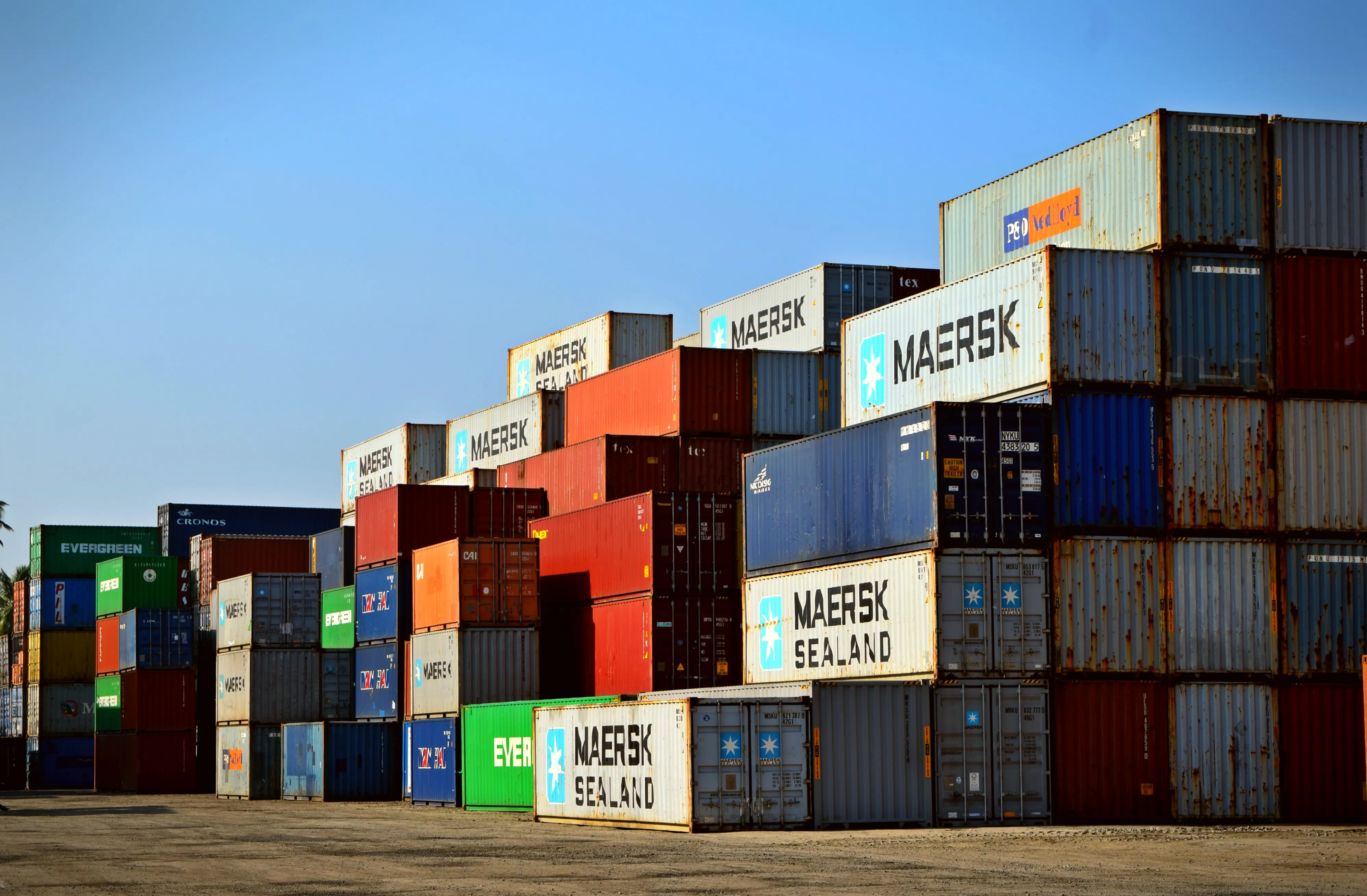 Stacked shipping containers at a port, representing the US-Canada trade war and tariffs